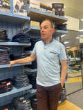 Man standing in a store with shelves displaying various items