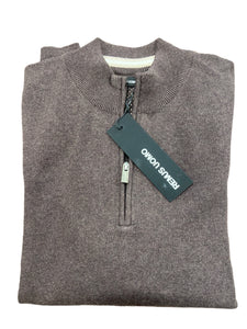 Folded gray sweater with a brand tag on a wooden surface